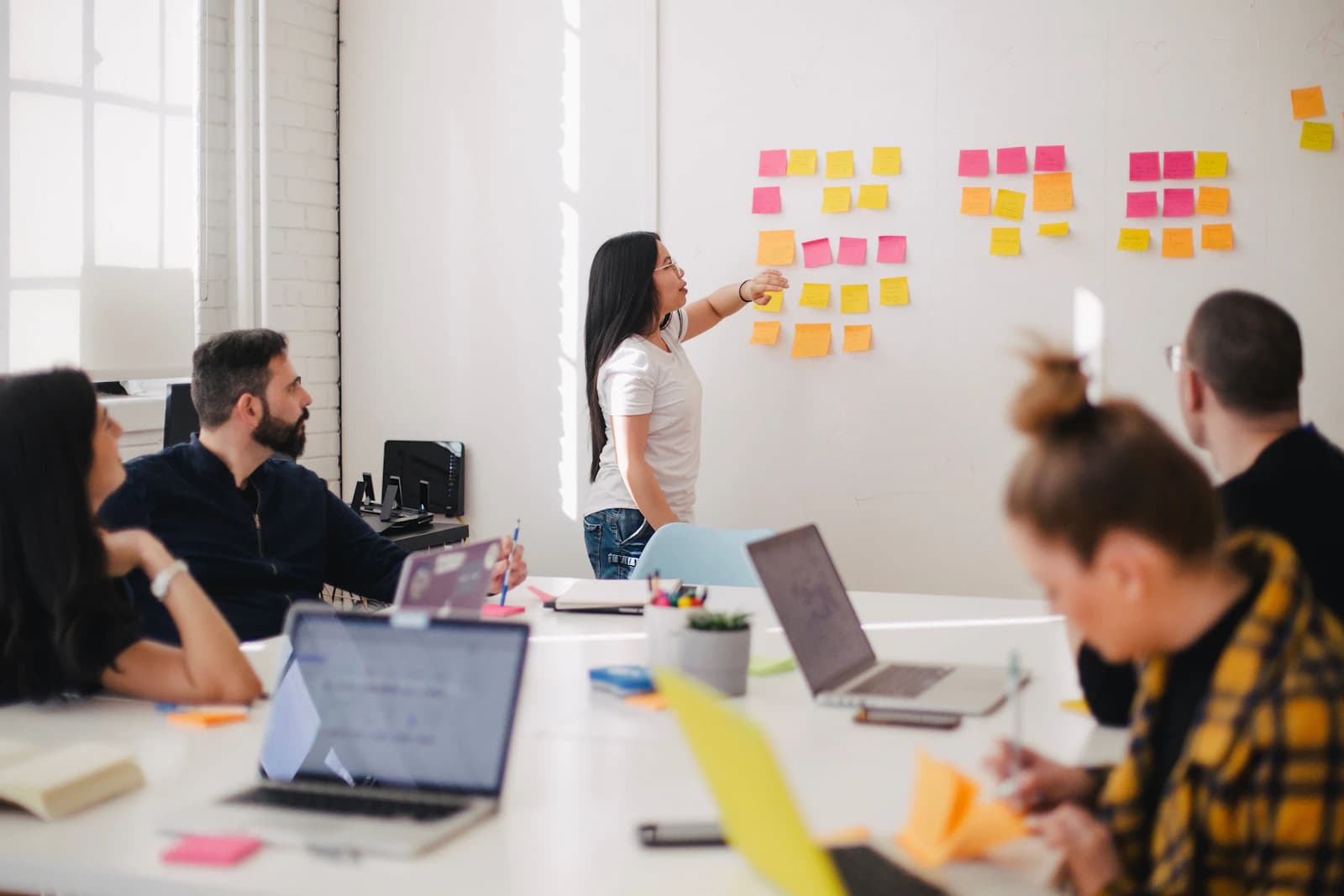 Team planning a project with sticky notes on a wall